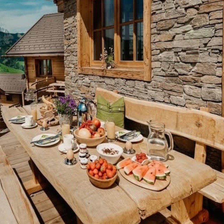 Frühstück auf der Terrasse im Chaletdorf BERGHERZ in Österreich – traumhafte Lage der Chalets und einzigartiger Blick beim Frühstücken in die Berge