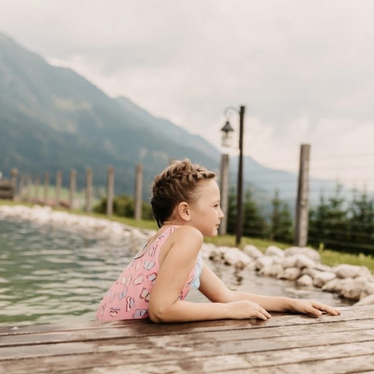 Almdorf BERGHERZ – Kind im Badesee im Chaletdorf BERGHERZ – traumhafte Lage – optimal für einen Familienurlaub im Sommer